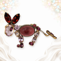 Vintage Schreiner pink and purple rhinestone donkey brooch with spring tail, front