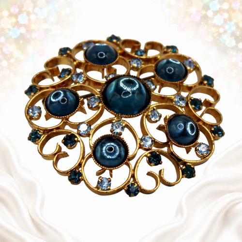 Angled detail showing domed blue Lucite cabochons and gold-tone heart scrollwork