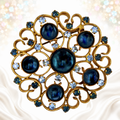 Vintage Juliana blue Lucite cabochon and light blue rhinestone heart-scroll brooch in gold-tone metal, front view
