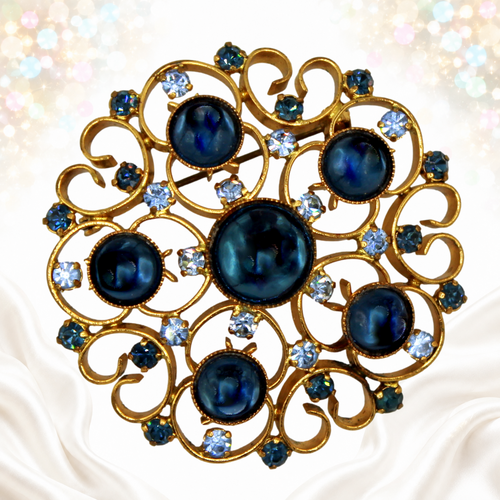 Vintage Juliana blue Lucite cabochon and light blue rhinestone heart-scroll brooch in gold-tone metal, front view
