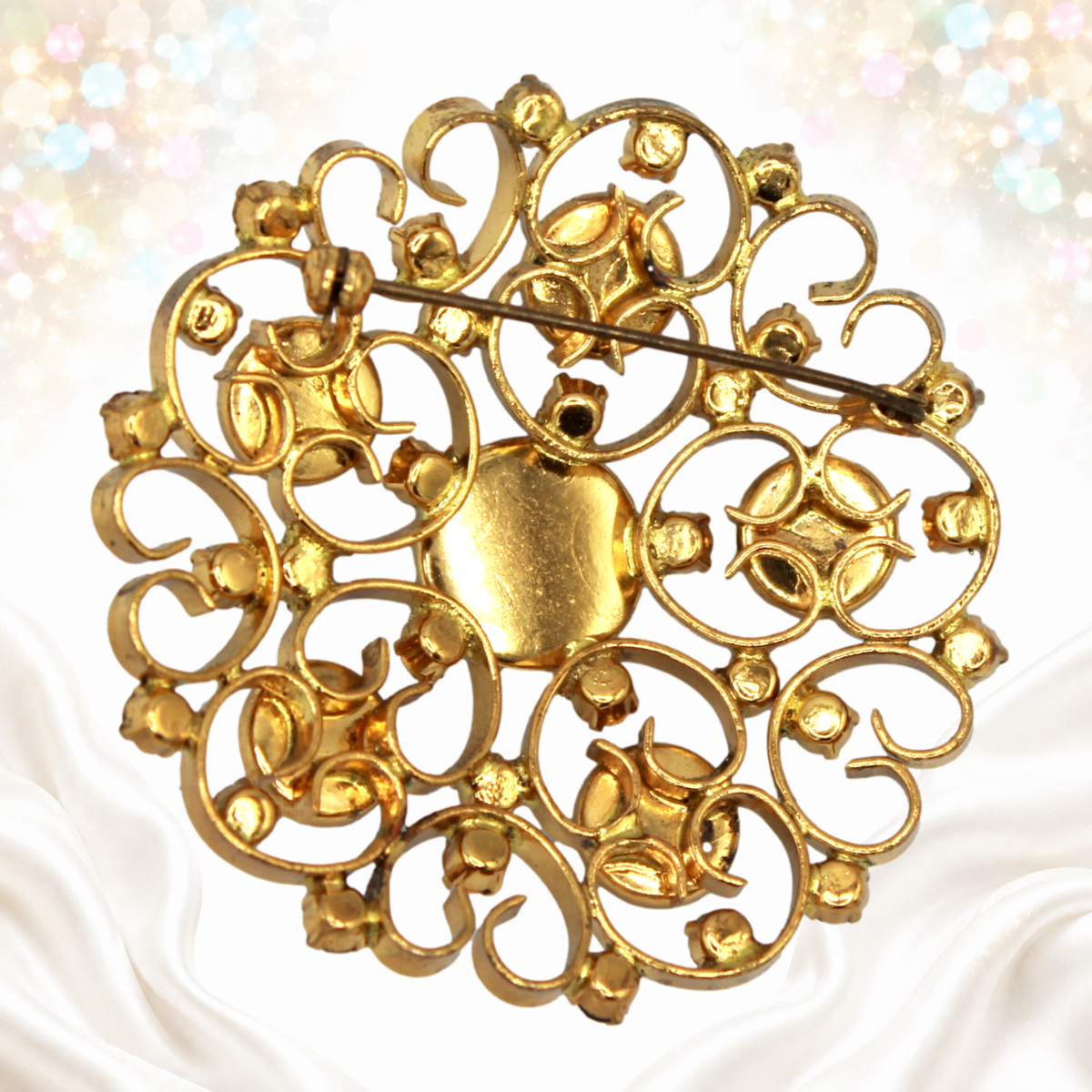 Reverse of Juliana heart-scroll brooch showing settings and pin fastening