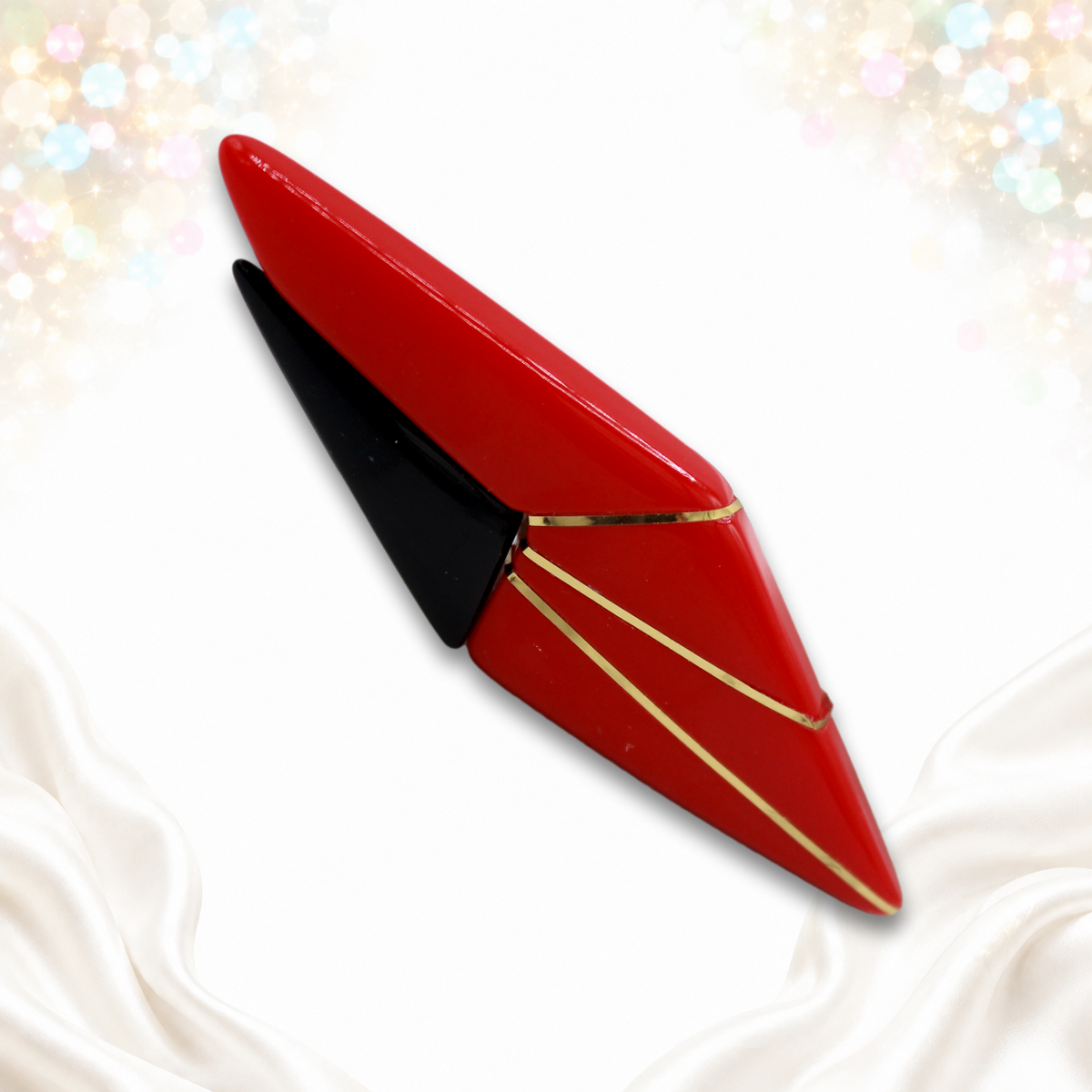 Angled front of red and black geometric plastic brooch