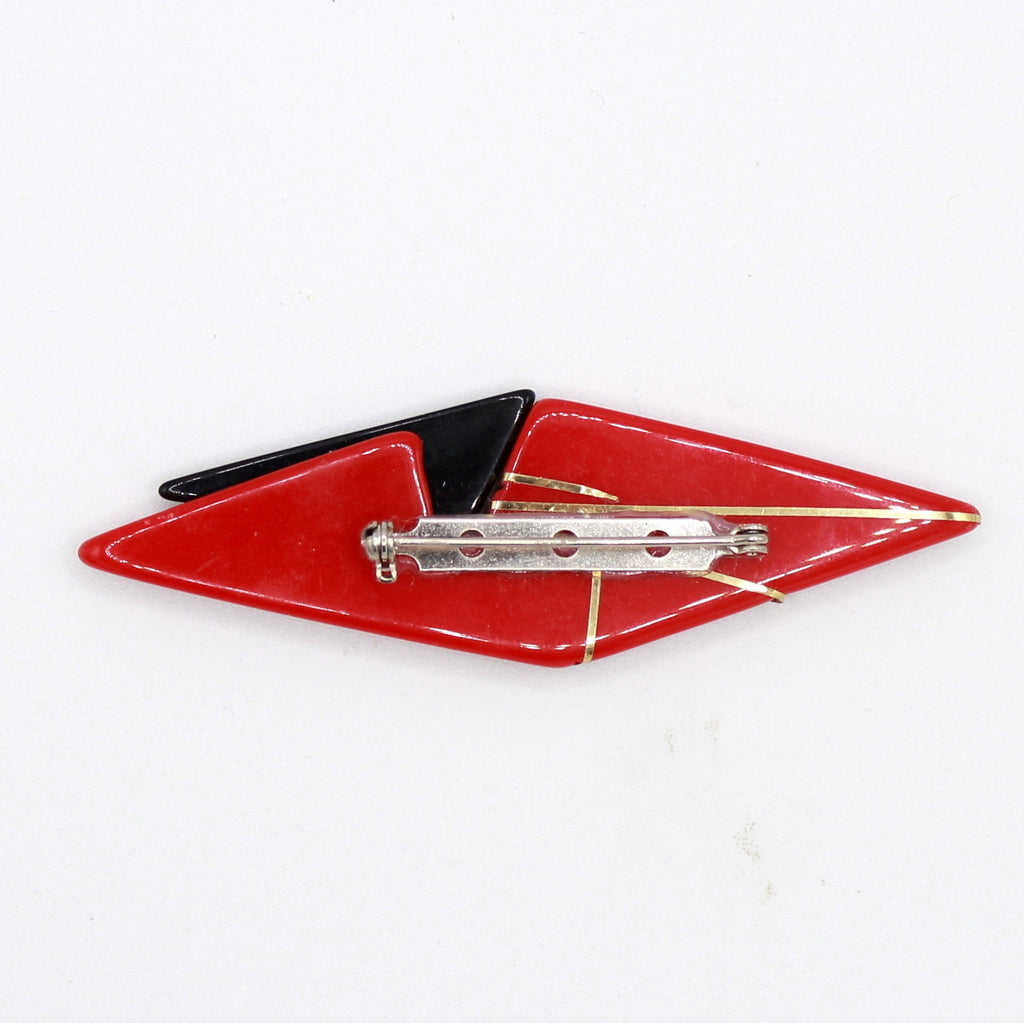 Back of red and black plastic geometric brooch showing pin fastening