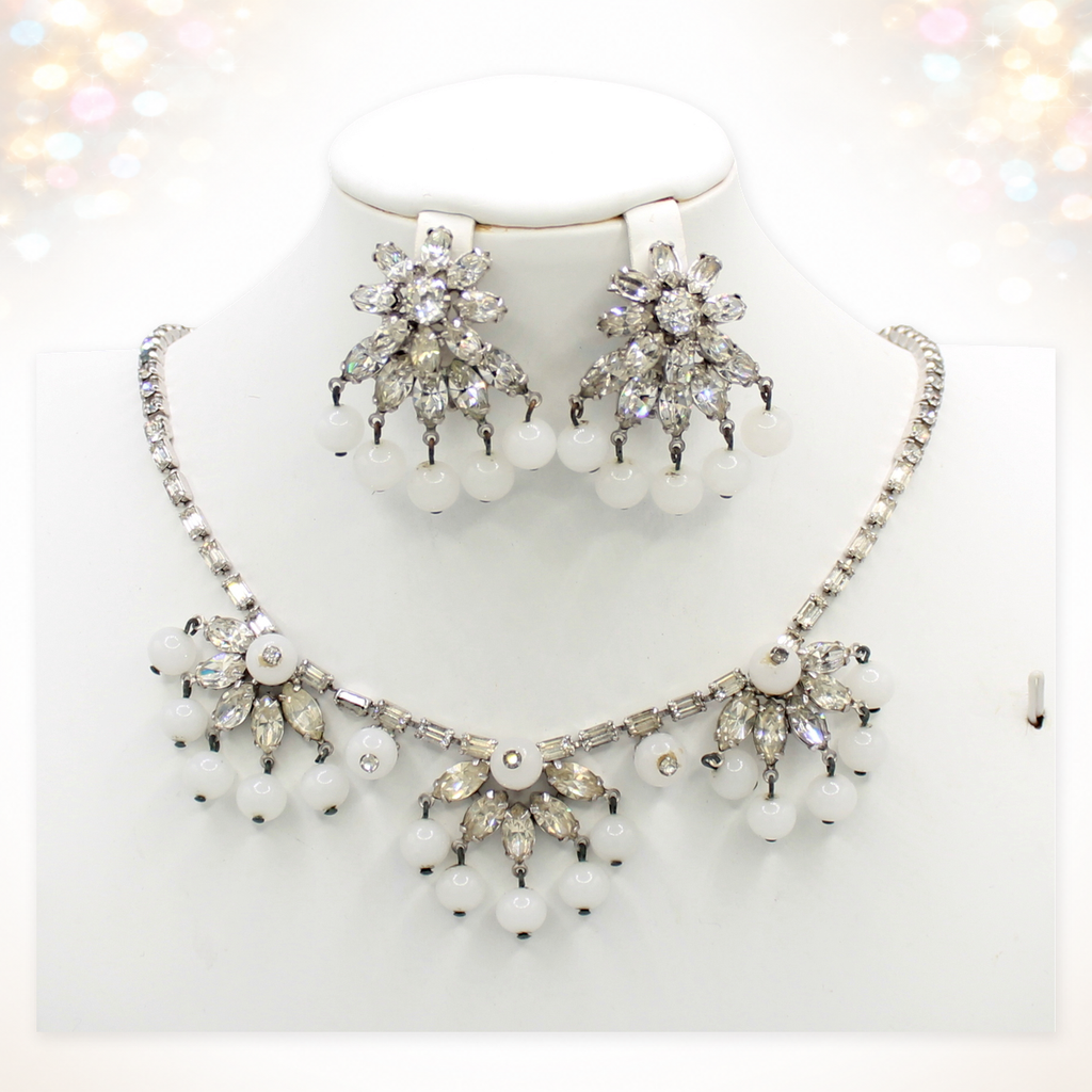 Signed Weiss clear rhinestone and white bead necklace and clip earrings on white bust