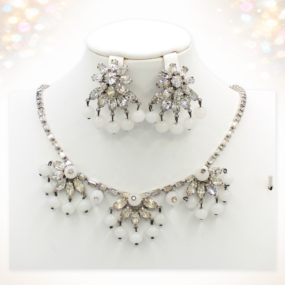 Signed Weiss clear rhinestone and white bead necklace and clip earrings on white bust