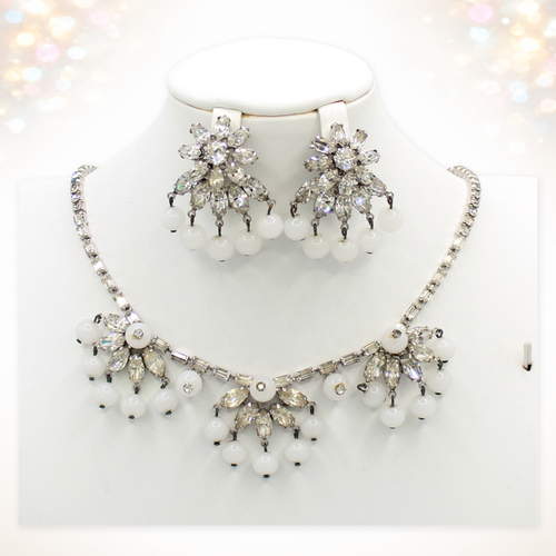 Signed Weiss clear rhinestone and white bead necklace and clip earrings on white bust