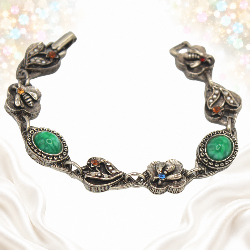 Detail view of faux jade stones and bee motifs on bracelet