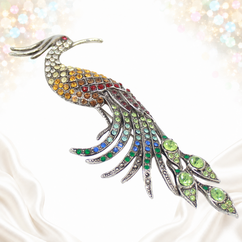 Angled view showing the sweeping rhinestone tail and silver-tone peacock casting