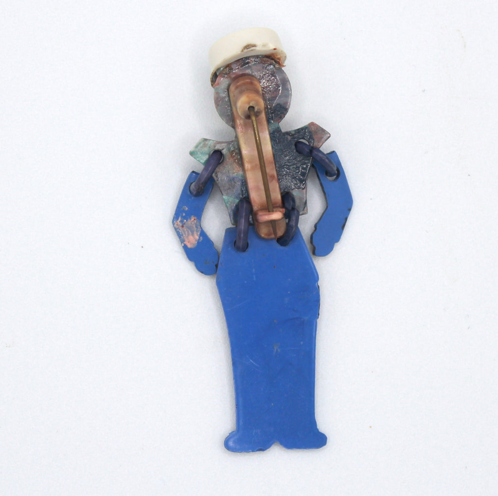Back of vintage plastic soldier brooch showing pin and articulated connections