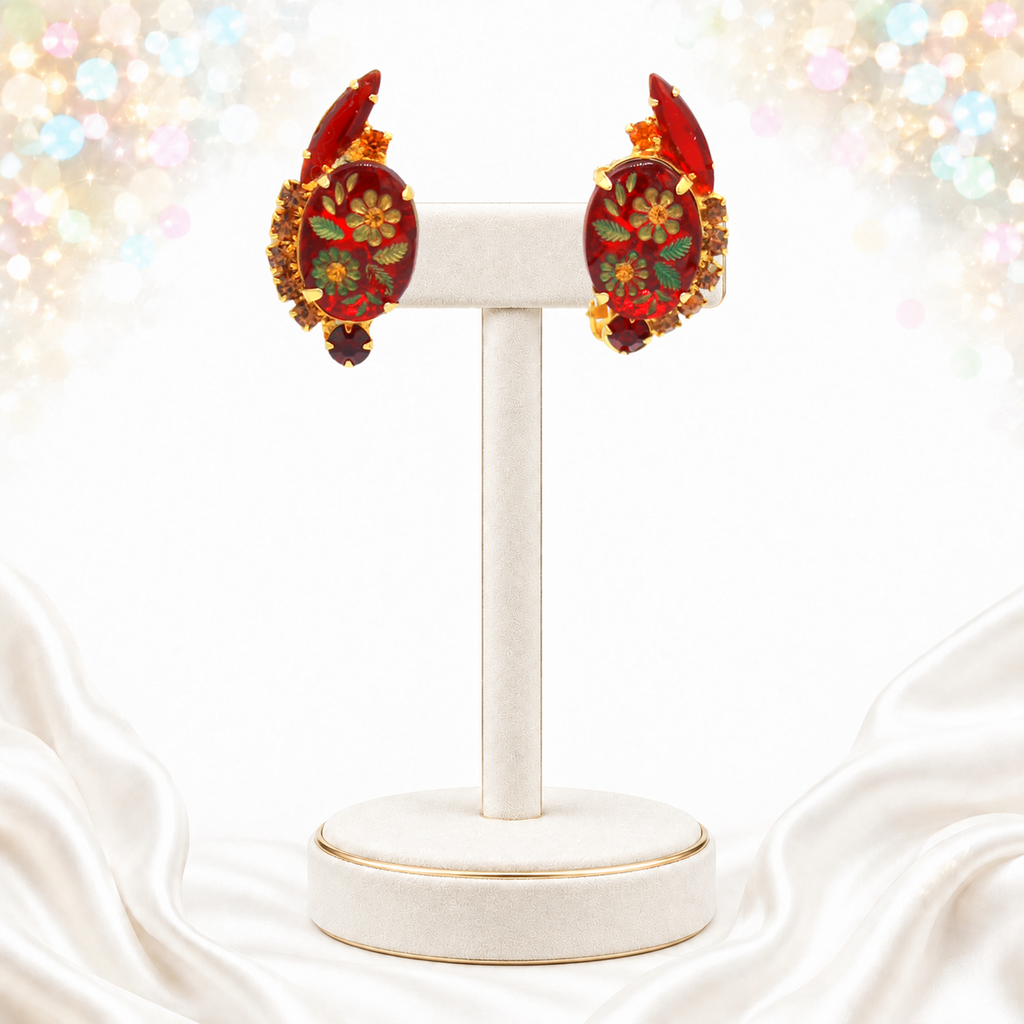 Front view of vintage red glass engraved flower Juliana clip earrings on display stand