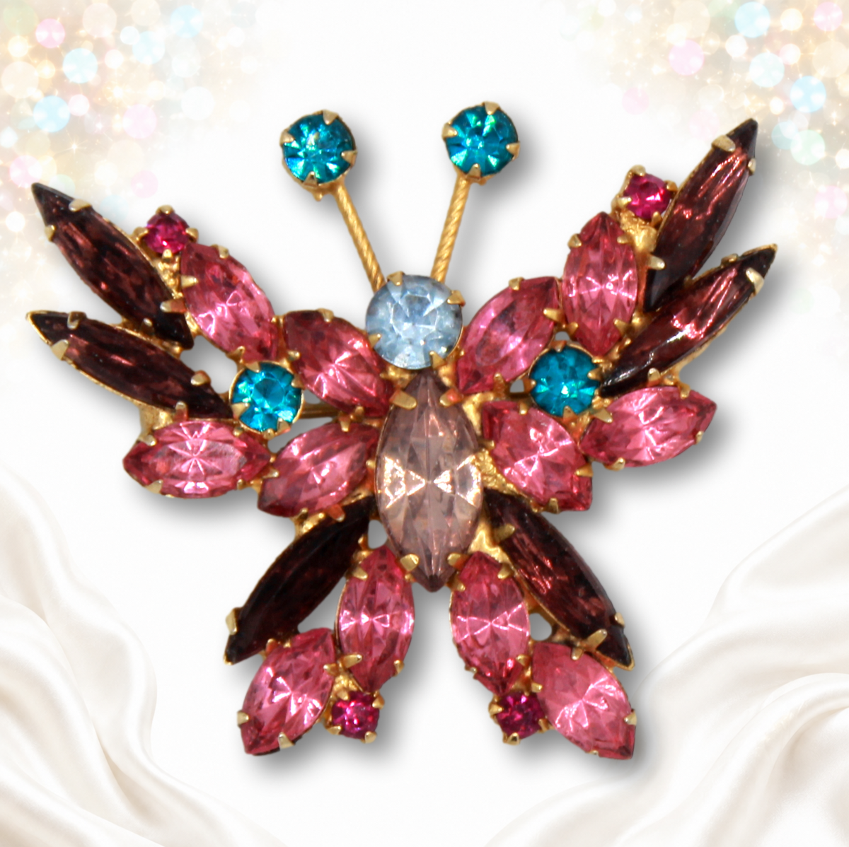 Front view of pink and teal rhinestone butterfly brooch