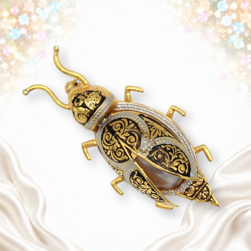 Vintage damascene-style beetle brooch with gold and silver tone scroll decoration