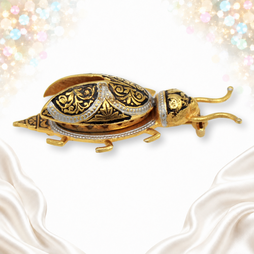 Vintage damascene-style beetle brooch with gold and silver tone scroll decoration