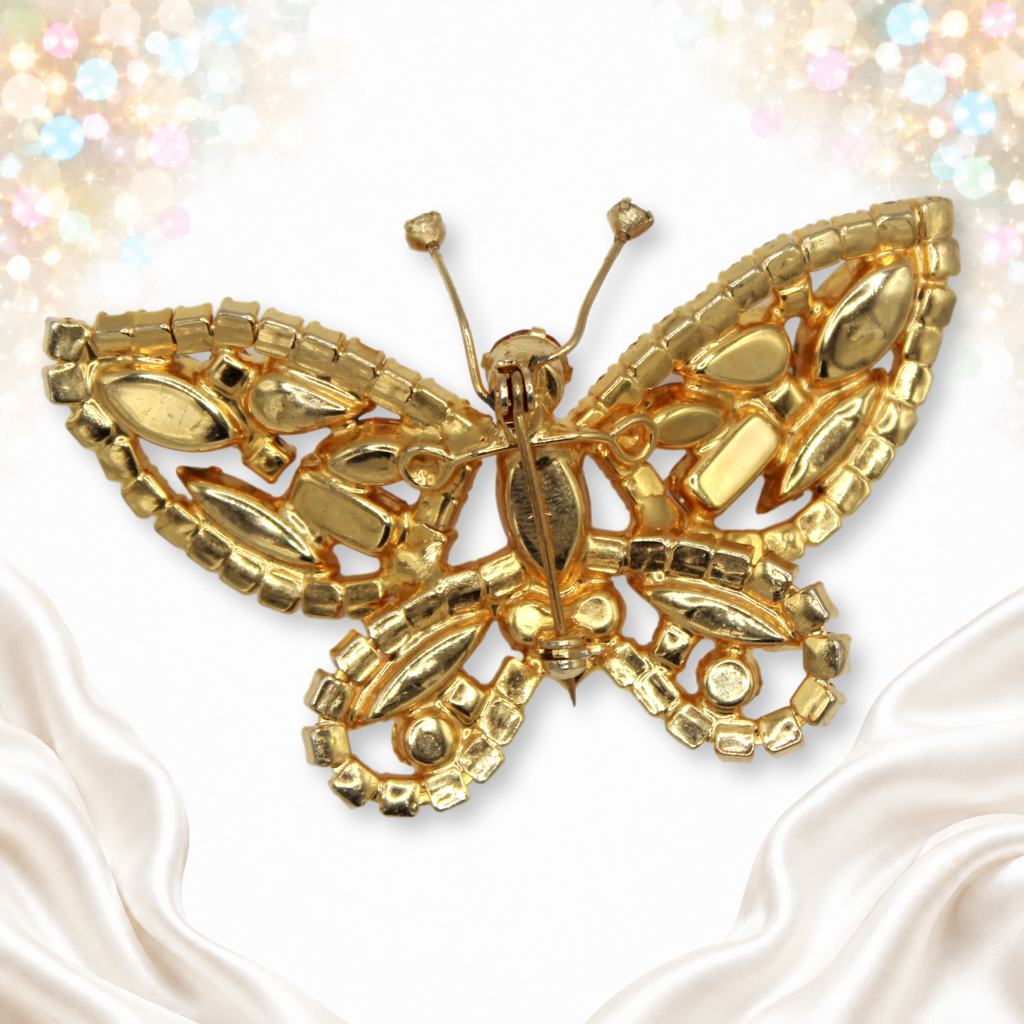 Reverse of butterfly brooch showing figure 8’s, support wire and pin back