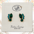 Juliana teal and green rhinestone clip earrings on their original presentation card