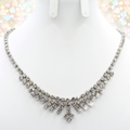 Actual clear rhinestone arrow fringe necklace on a white bust