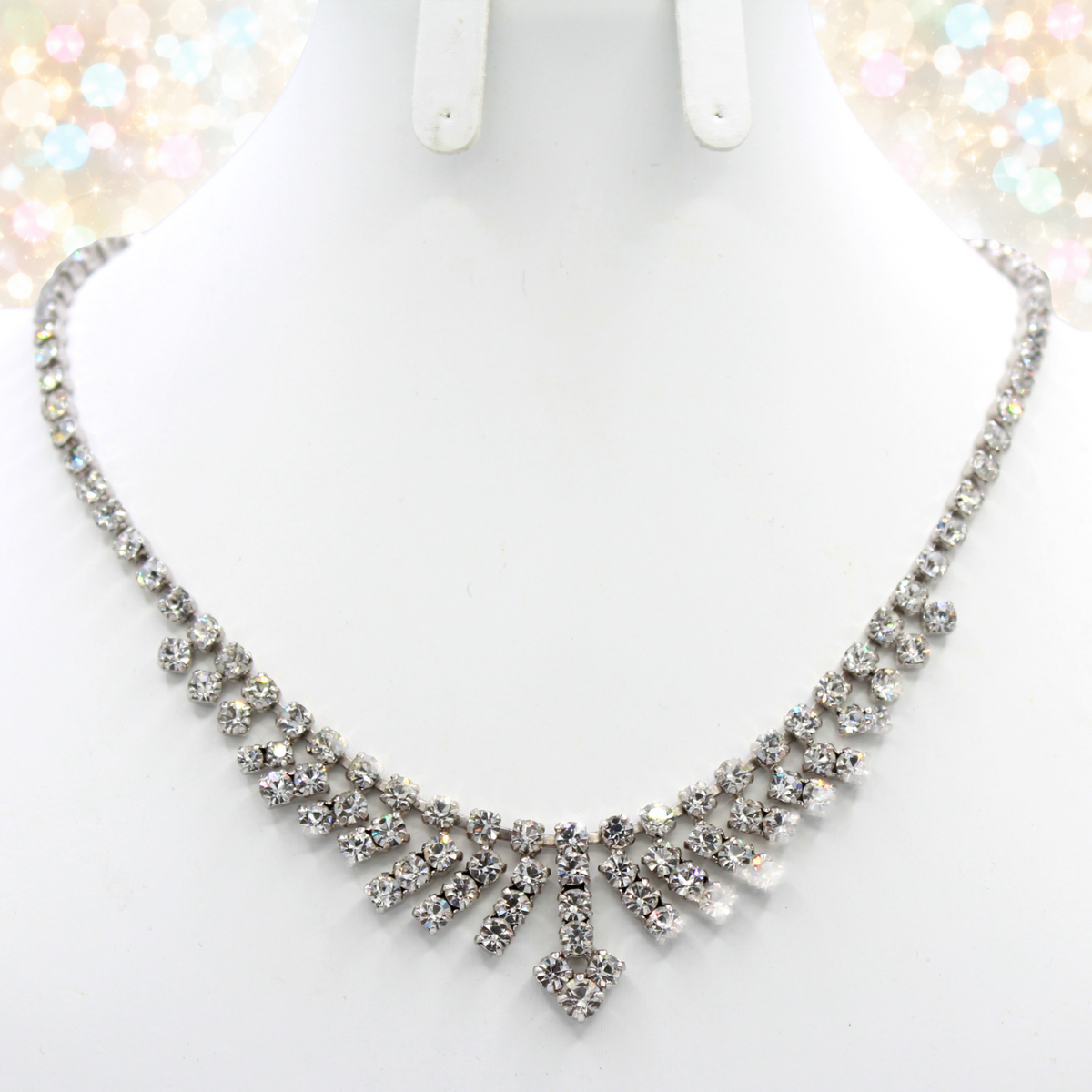 Actual clear rhinestone arrow fringe necklace on a white bust