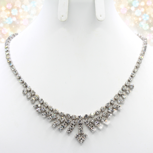 Actual clear rhinestone arrow fringe necklace on a white bust