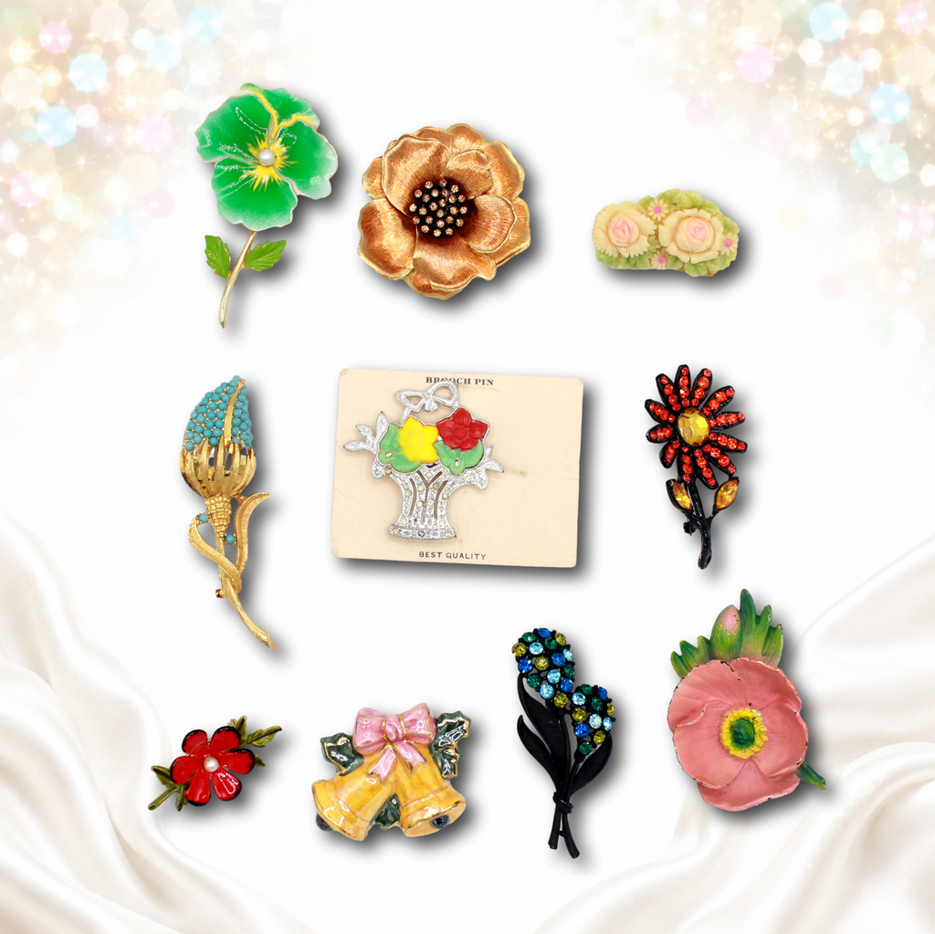 Front view of ten colorful assorted vintage flower and figural brooches displayed on white satin with pastel sparkle accents