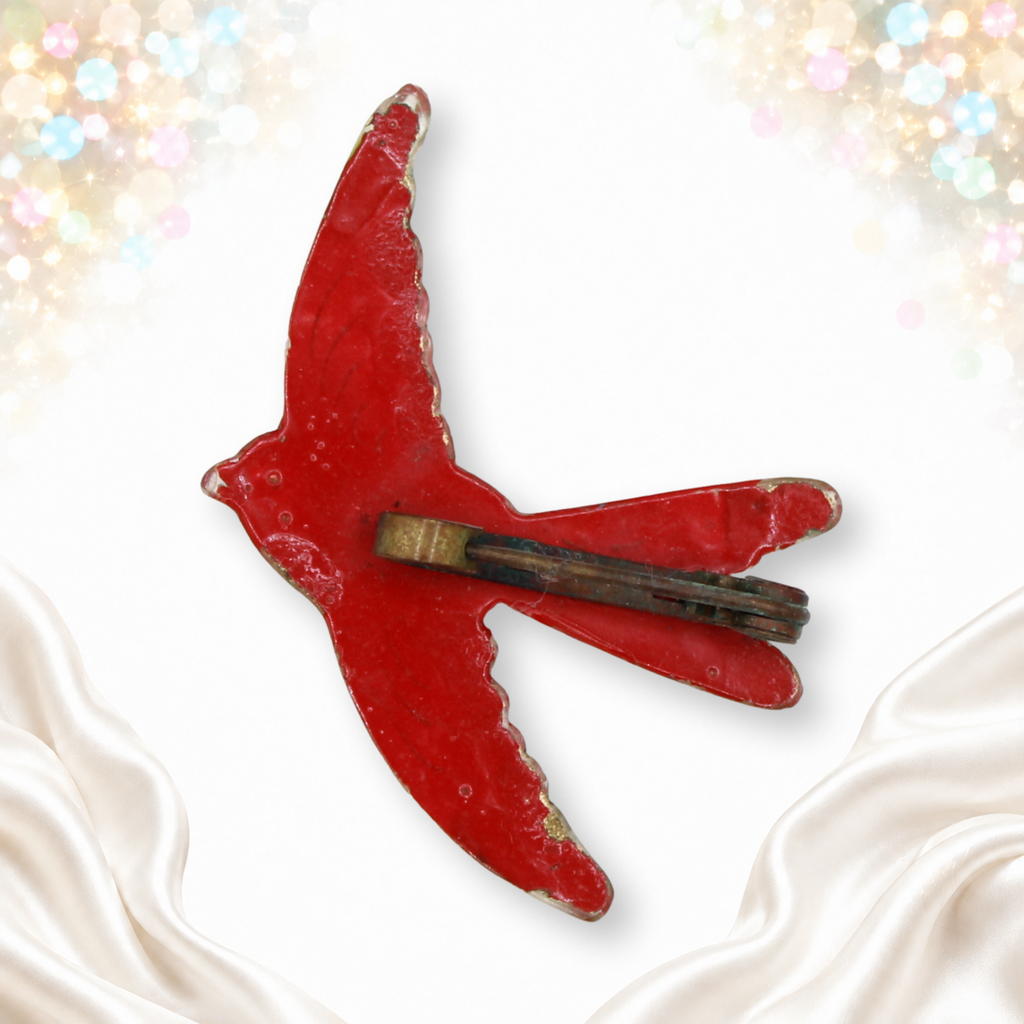 Reverse of painted plastic bird brooch showing paint wear and pin hardware