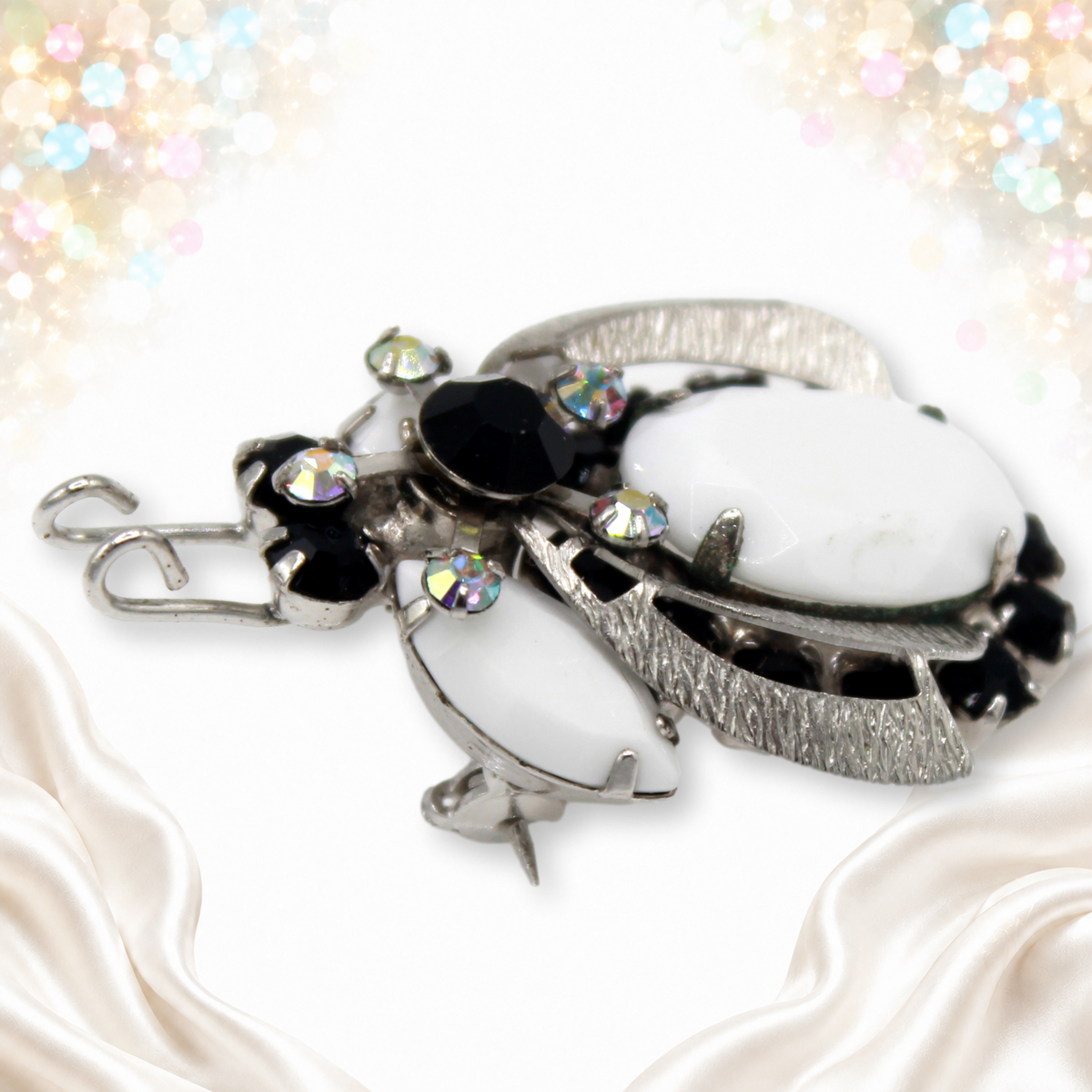 Angled view of dimensional Juliana black white and AB rhinestone beetle